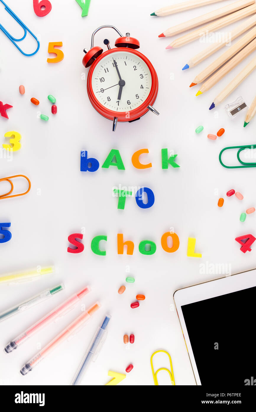 Creative flat lay back to school concept blank tablet with alarm clock ...