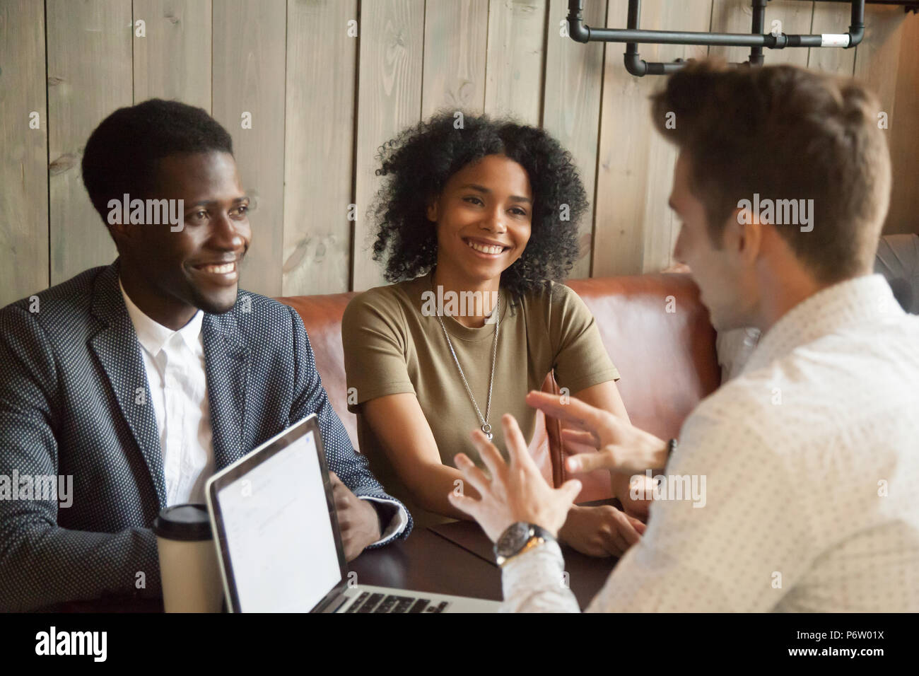 Caucasian architect consulting black clients out in coffee shop Stock Photo Alamy