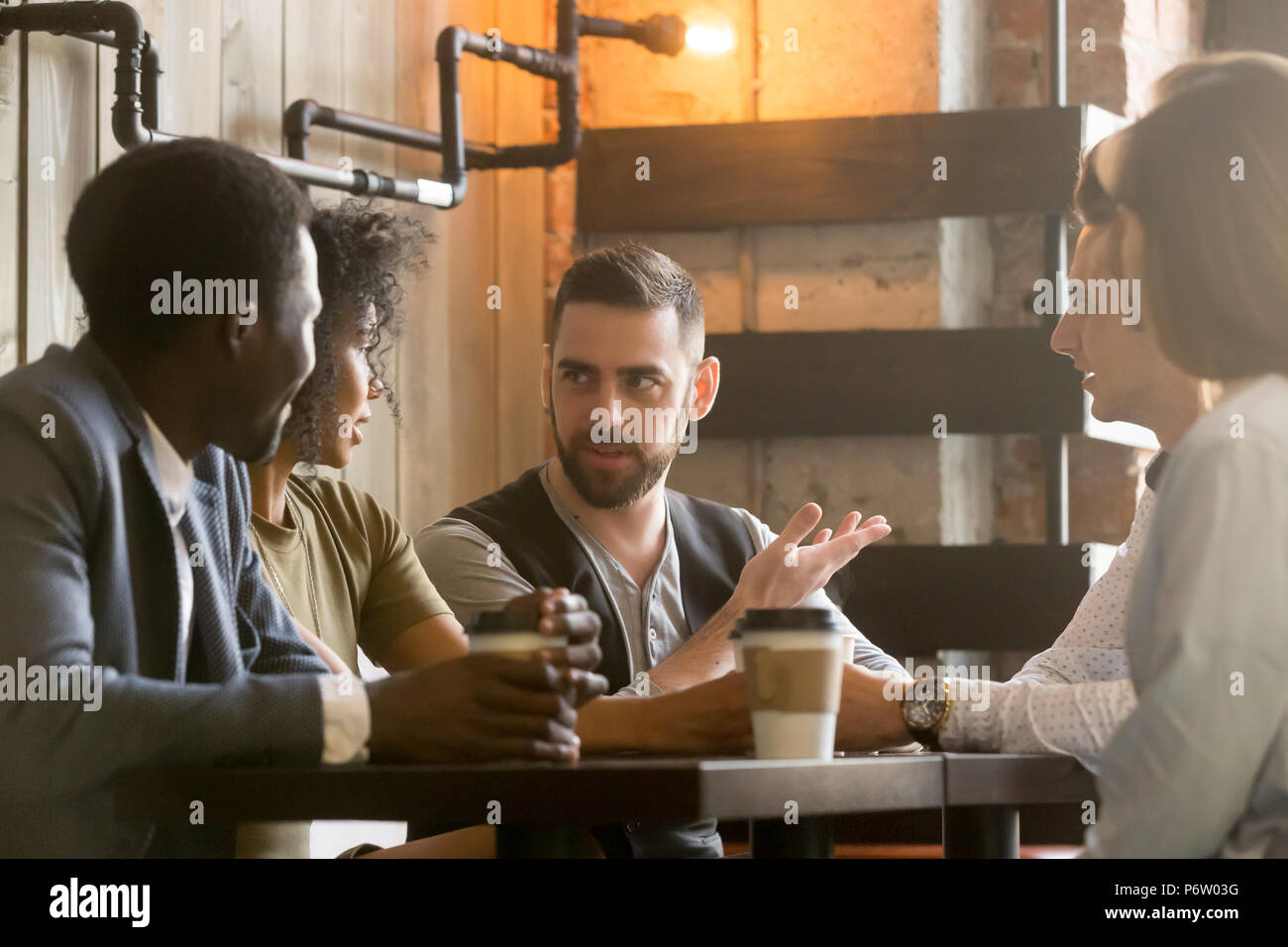Multiracial colleagues discussing ideas during work break in caf Stock Photo
