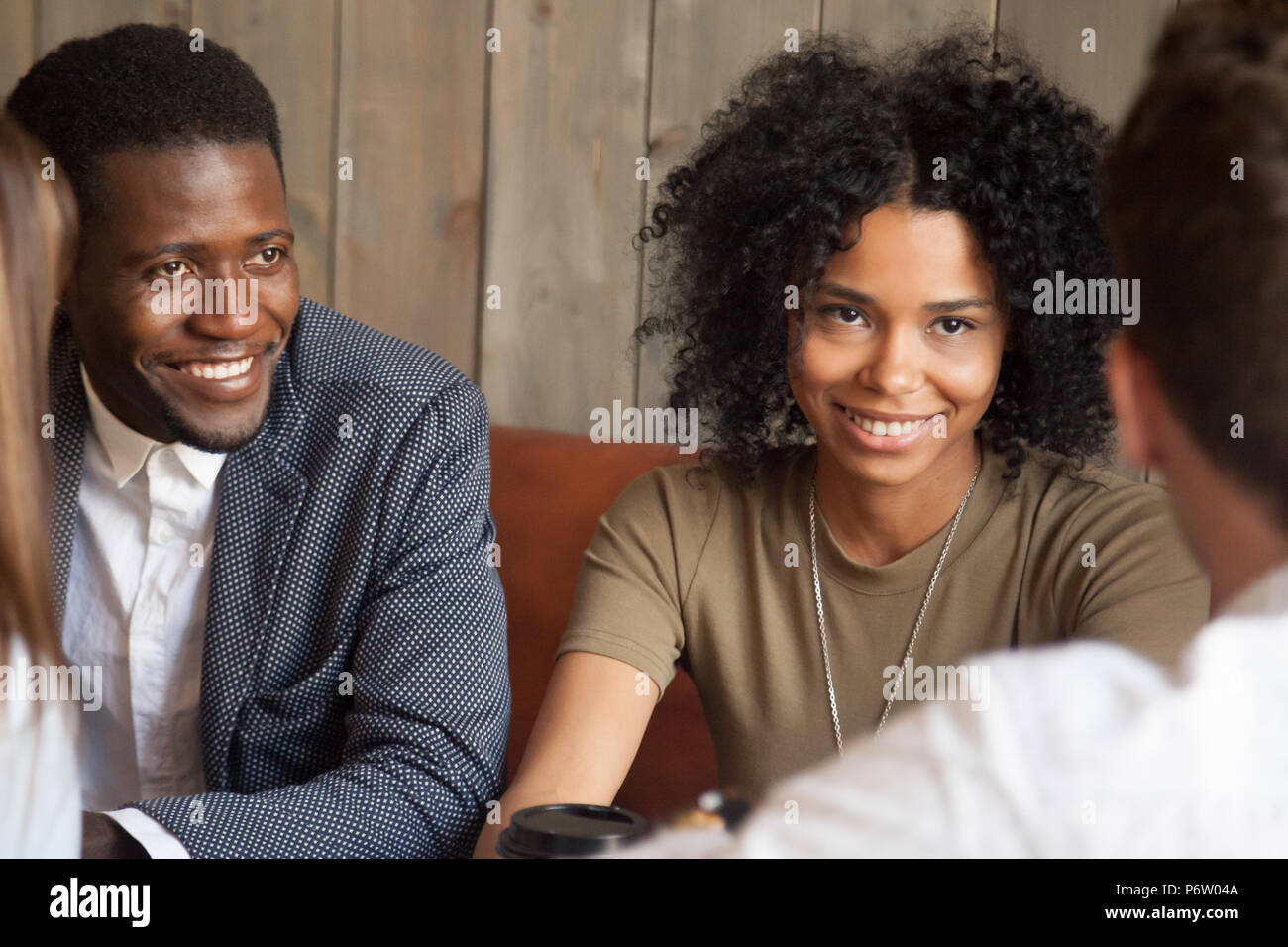 Happy black friends enjoying meeting with colleagues out in cafe Stock Photo