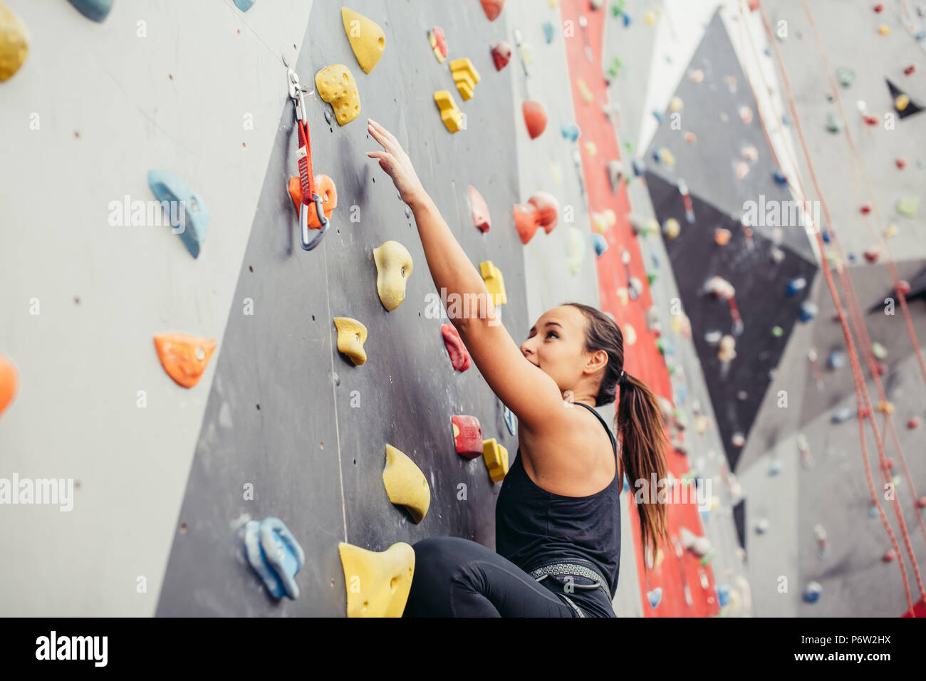 Sporty couple of climbers dressed in a rock climbing outfit training at the  bouldering gym Stock Photo - Alamy