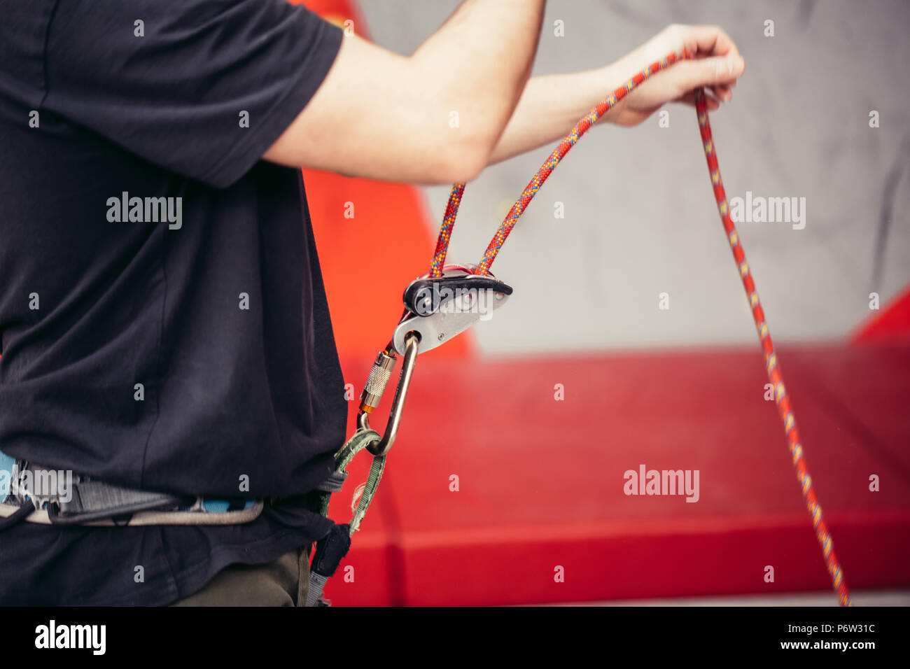Cropped view of female rock climber wearing safety harness and climbing equipment outdoor, close-up image Stock Photo