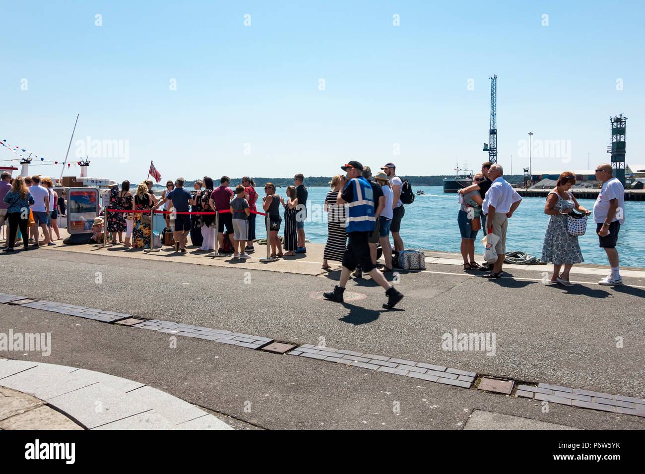 Tourists waiting for a boat harbour trip on Poole Quay in the summertime, Poole, Dorset, United Kingdom Stock Photo