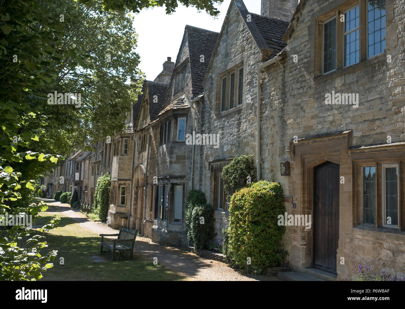Row of old stone houses facing a grass verge in Sheep Street off the