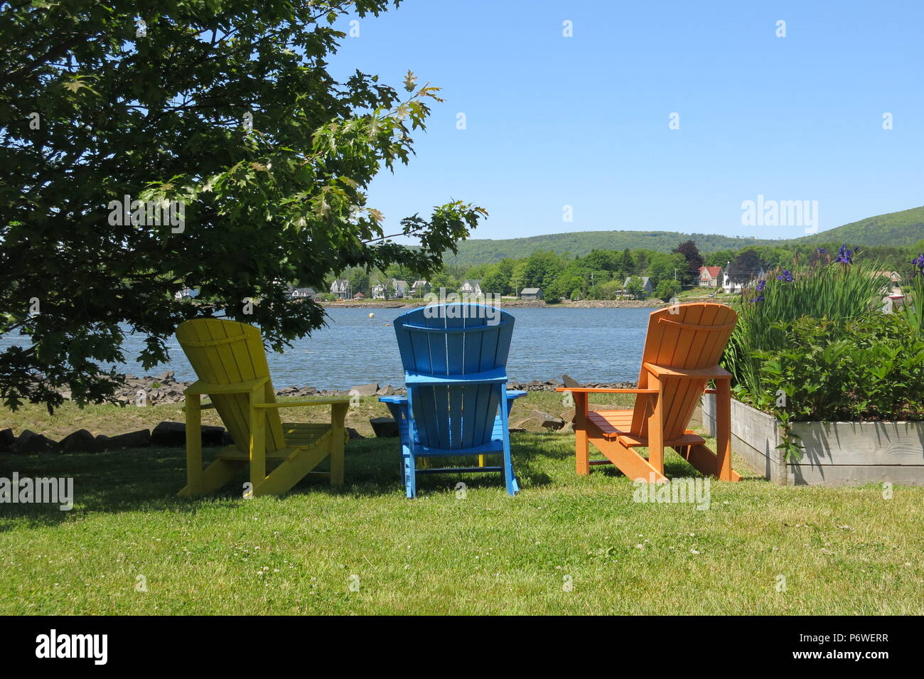 A Row Of Brightly Coloured Adirondack Chairs To Relax And Admire