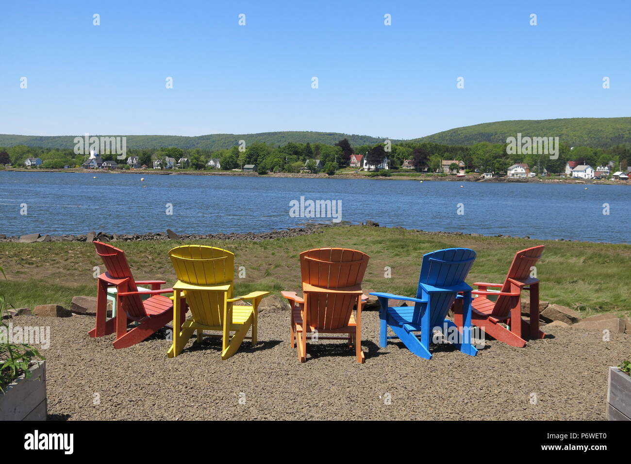 A Row Of Brightly Coloured Adirondack Chairs To Relax And Admire