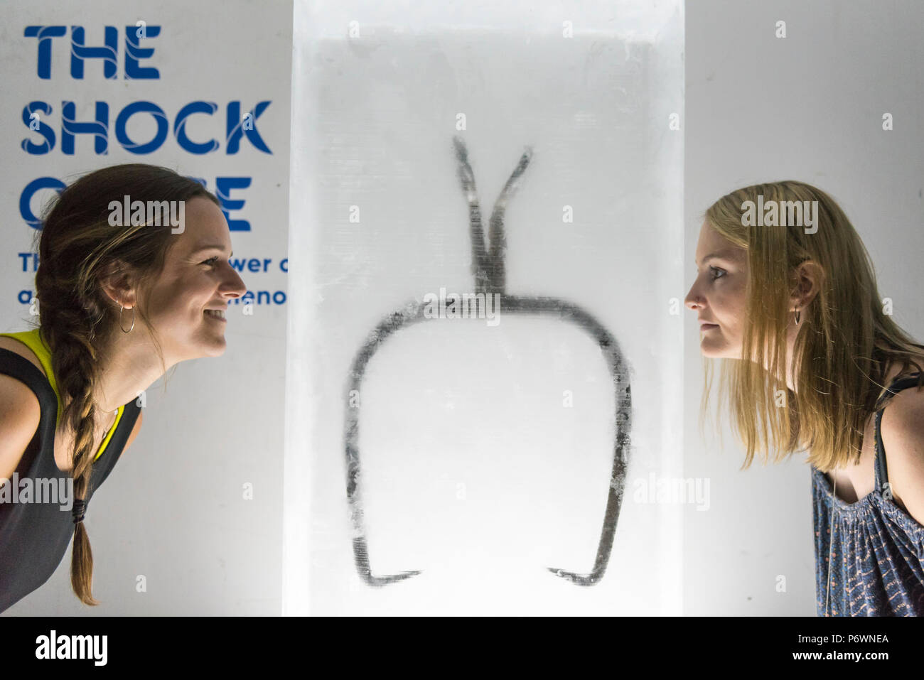 London, UK.  3 July 2018. Staff members view an Ice Hook (or Ice Dog) , circa 1910, presented encased in a block of ice, at a preview of 'SCOOP: A Wonderful Ice Cream World', the first official exhibition of the British Museum of Food.  The exhibition presents items from the Robin and Caroline Weir Collection and explores the science and appeal of ice cream going back 400 years.  The exhibition takes place at the Gasholders near Granary Square in Kings Cross and runs 3 July to 30 September 2018.. Credit: Stephen Chung / Alamy Live News Stock Photo