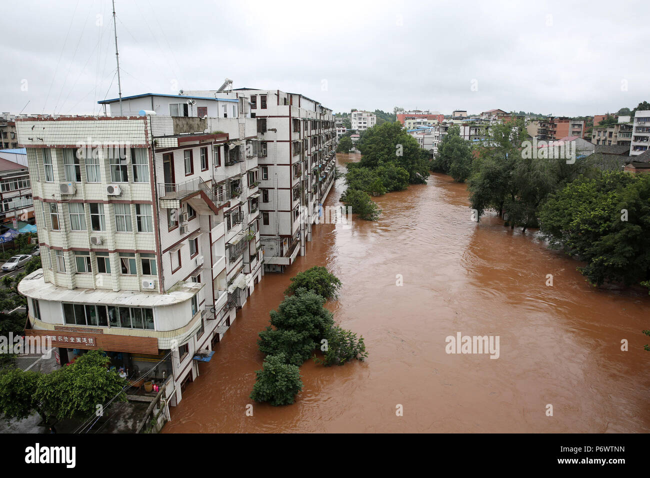 Neijiang. 3rd July, 2018. Photo taken on July 3, 2018 shows residential buildings in flood water in Tianjia Township of Neijiang, southwest China's Sichuan Province. Provincial flood control headquarters said a total of 115,900 people in Sichuan were affected by heavy rains. Crops, roads, bridges and school buildings were damaged. Credit: Lan Zitao/Xinhua/Alamy Live News Stock Photo
