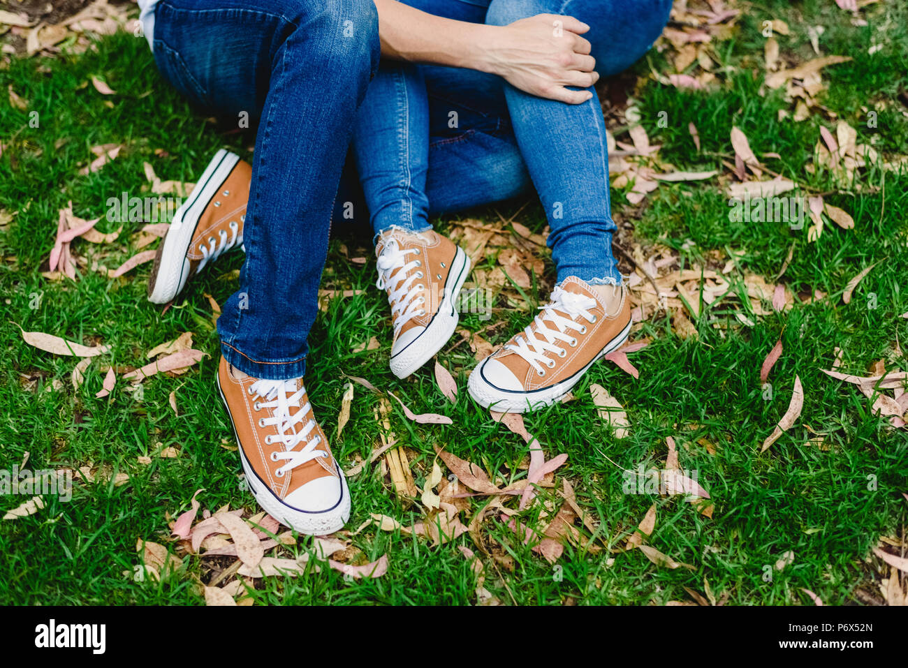 Couple sitting on a log with their legs crossed Stock Photo Alamy
