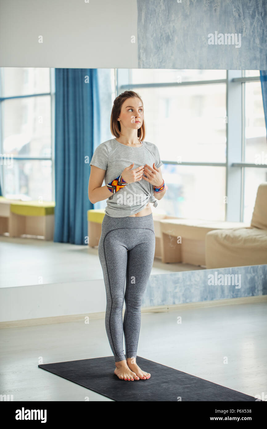 Full-size view of fit woman standing in the yoga studio. Fitness