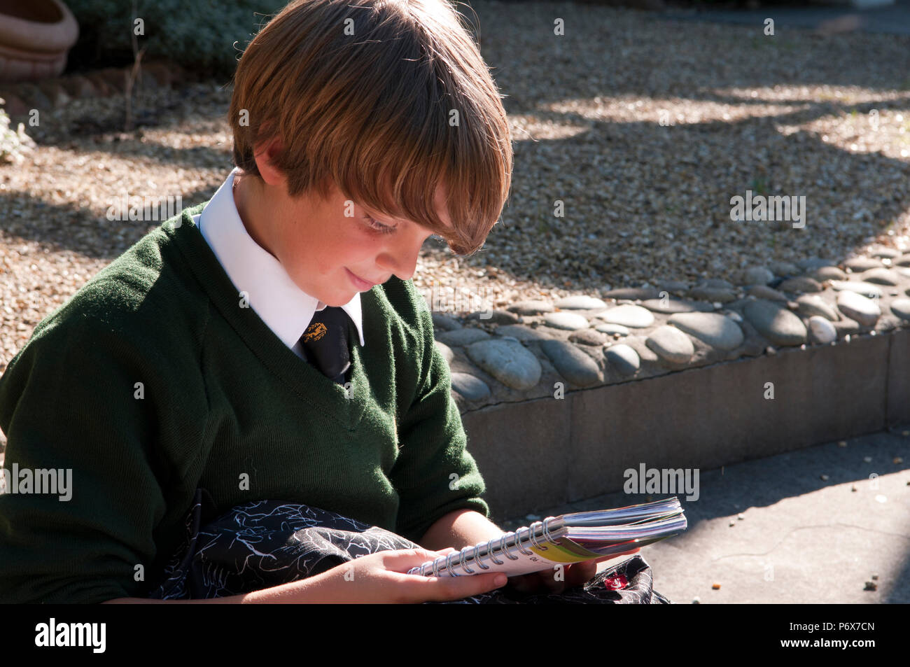 Schoolboy looking down at his school books Stock Photo