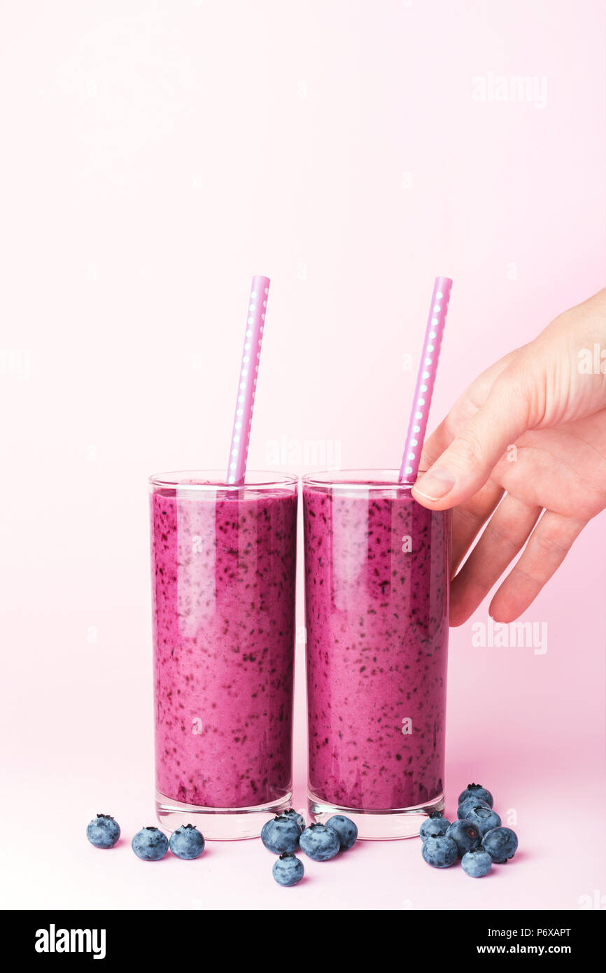 https://c8.alamy.com/comp/P6XAPT/two-glasses-of-blueberries-smoothie-with-straws-on-pink-background-womans-hand-taking-one-glass-healthy-summer-drink-P6XAPT.jpg