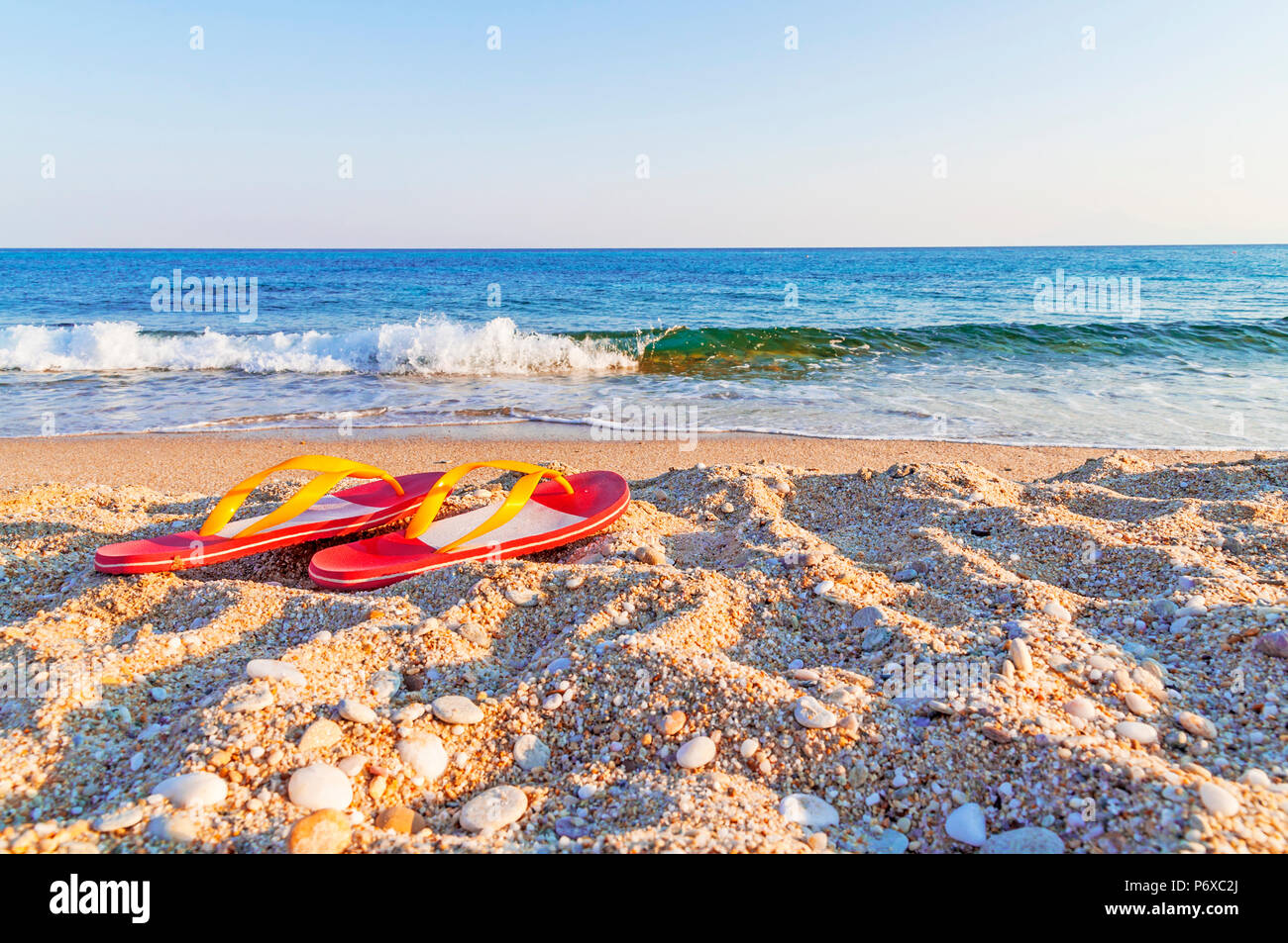 Flip flops on a sandy ocean beach Stock Photo - Alamy