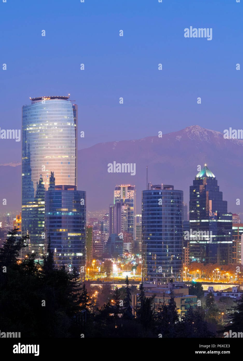 Chile, Santiago, Twilight view from the Parque Metropolitano towards the high raised buildings in financial sector. Snow covered Andes in the background. Stock Photo