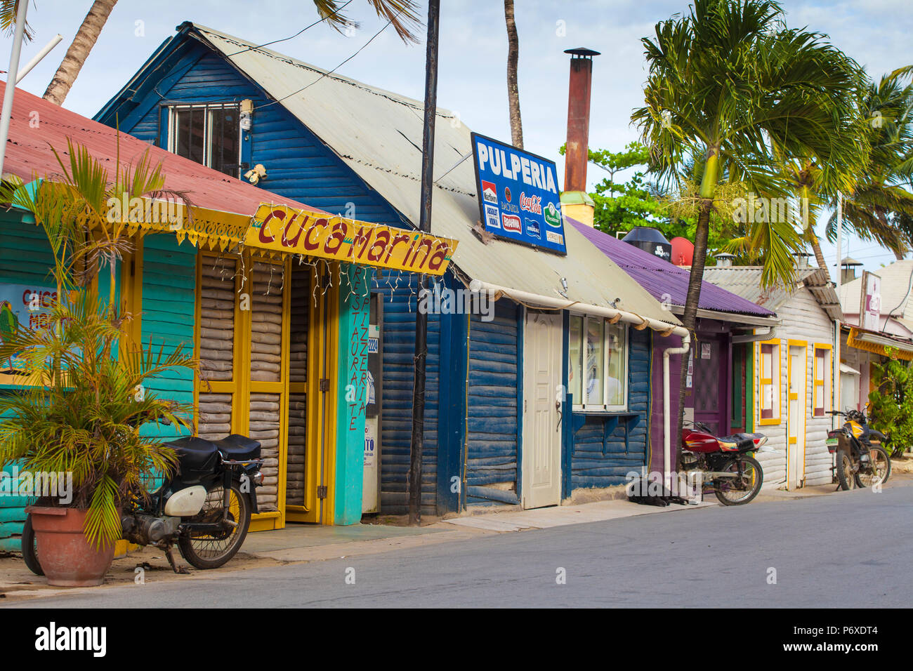 Dominican Republic, Samana Peninsula, Las Terrenas, People riding  motorbikes past former Fishermans huts which are now trendy restaurants  Stock Photo - Alamy