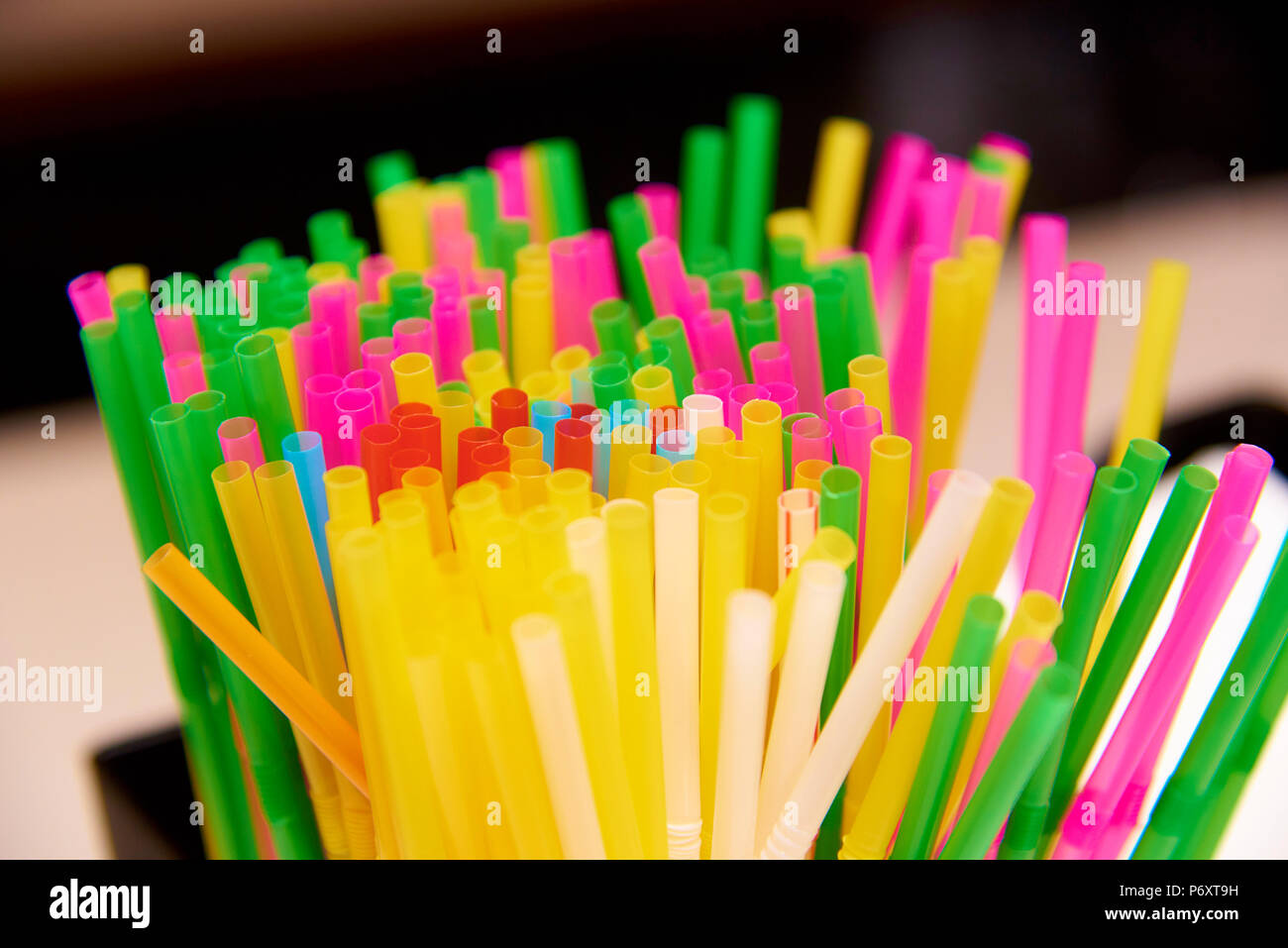 Bright multicolored straws close-up on a blurred background. Stock Photo