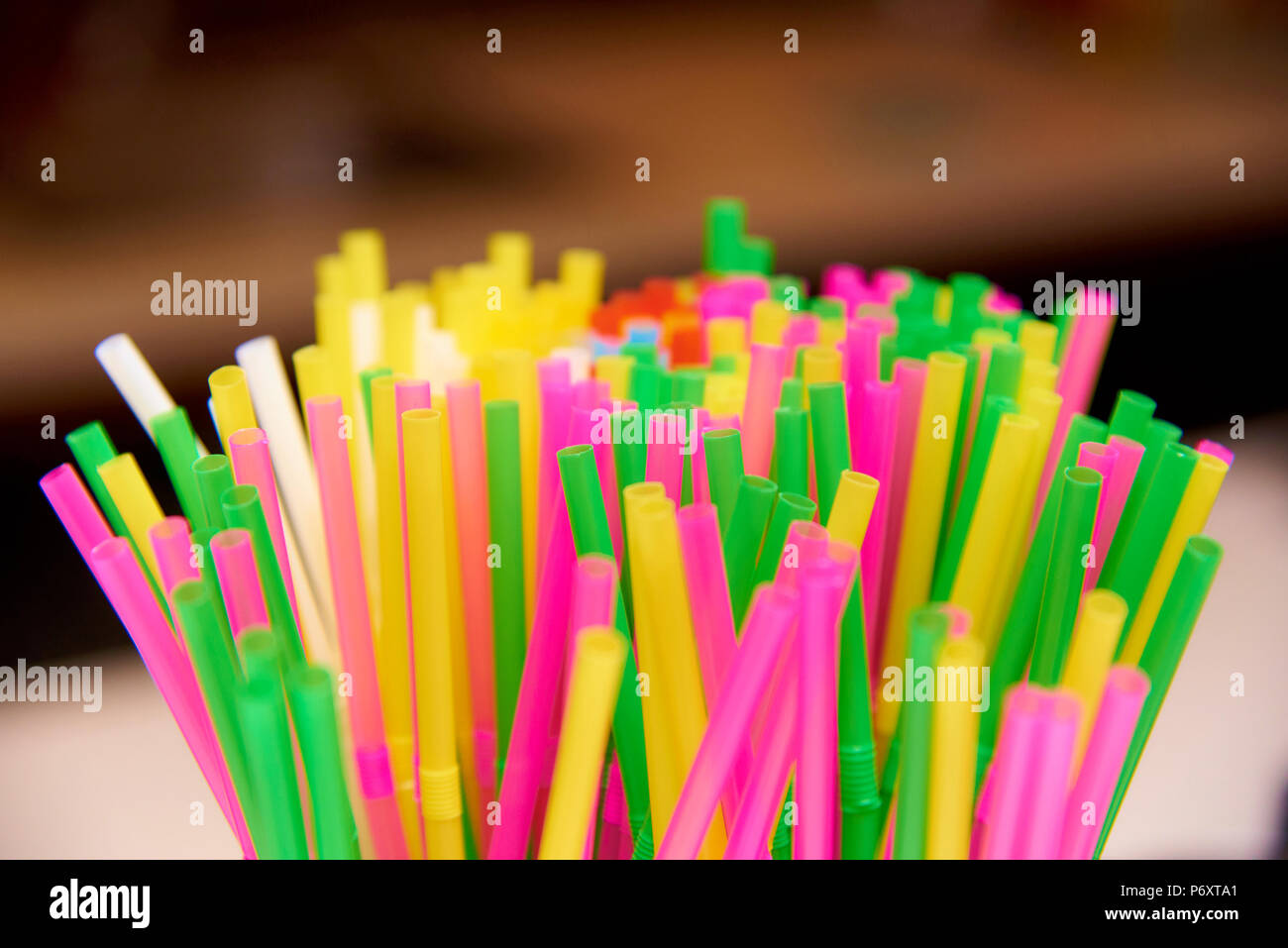 Bright multicolored straws close-up on a blurred background. Stock Photo