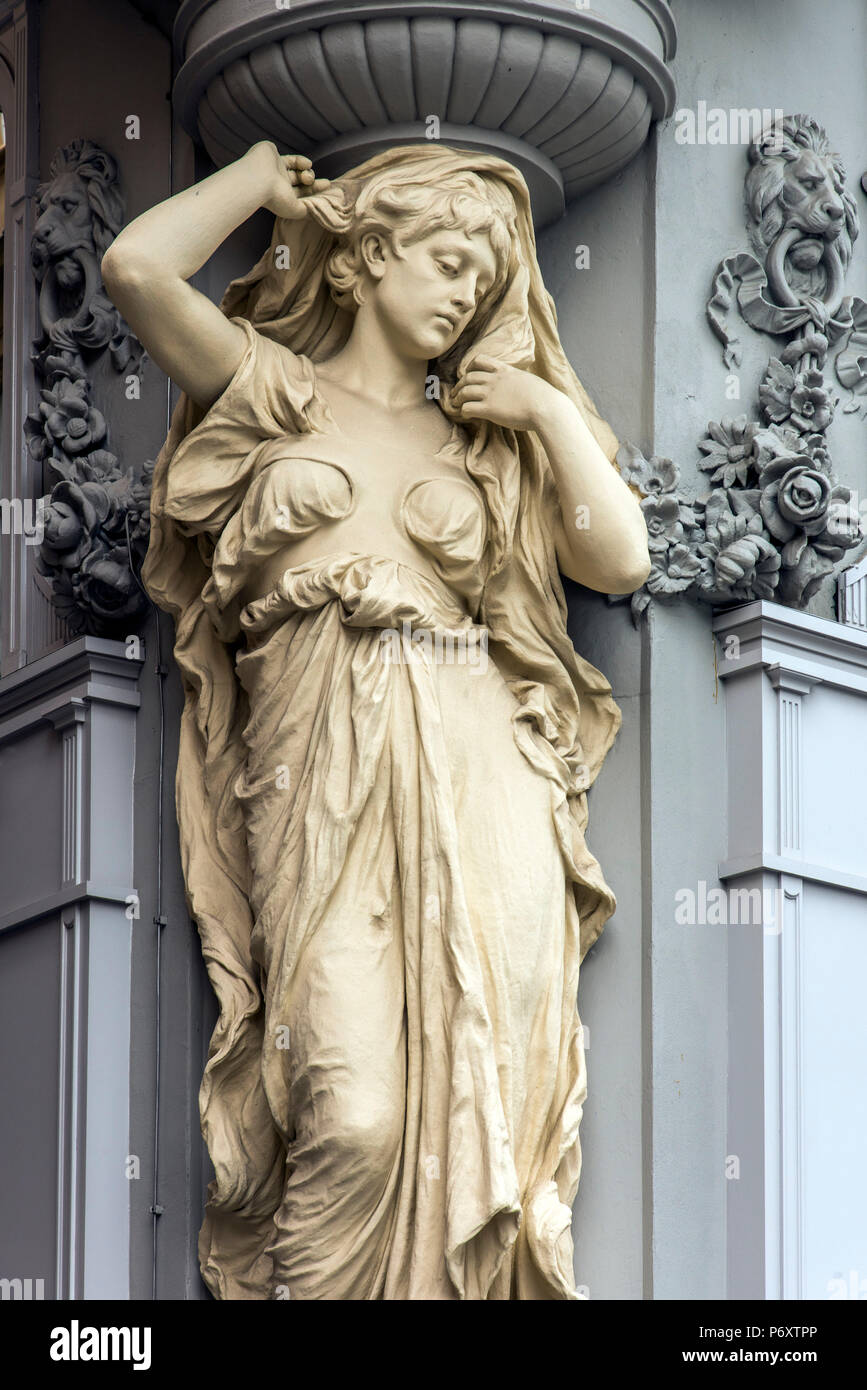 Caryatid sculpted female figure statue on the facade of a building in