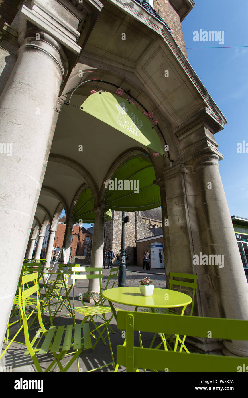 City of Canterbury, England. Empty cafe tables and chairs on Canterbury’s Burgate, with St Mary Magdalen's Church tower in the background. Stock Photo