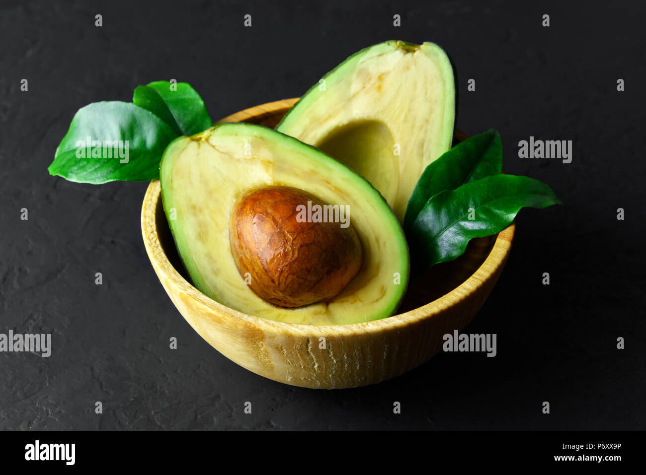Fresh avocado fruit on a wooden board Stock Photo