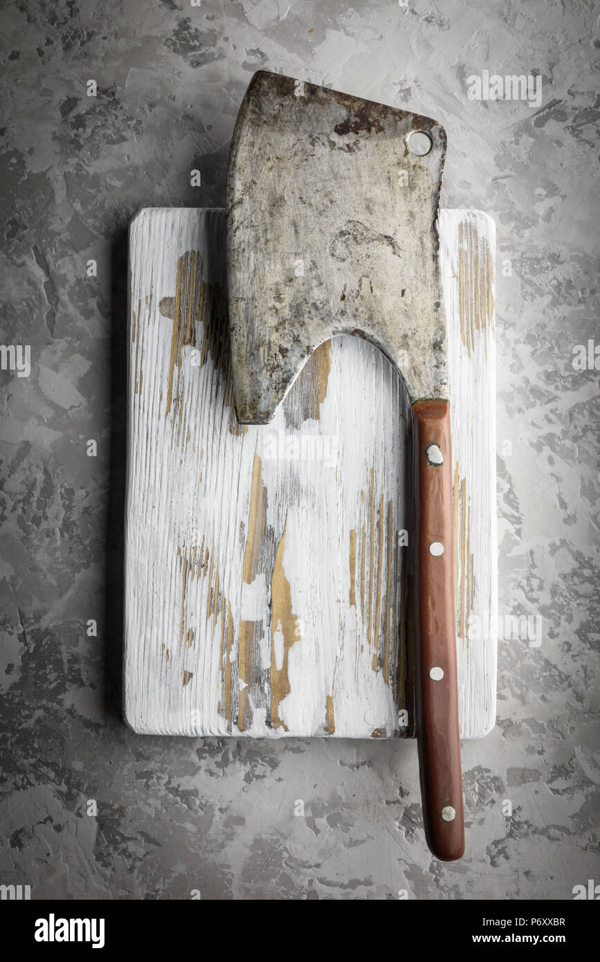 Old rustic axe for meat on a wooden board Stock Photo
