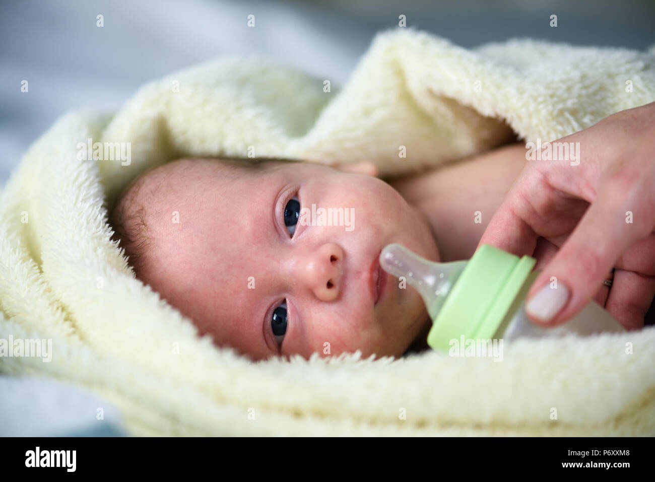 Newborn baby boy with plastik bottle closeup Stock Photo