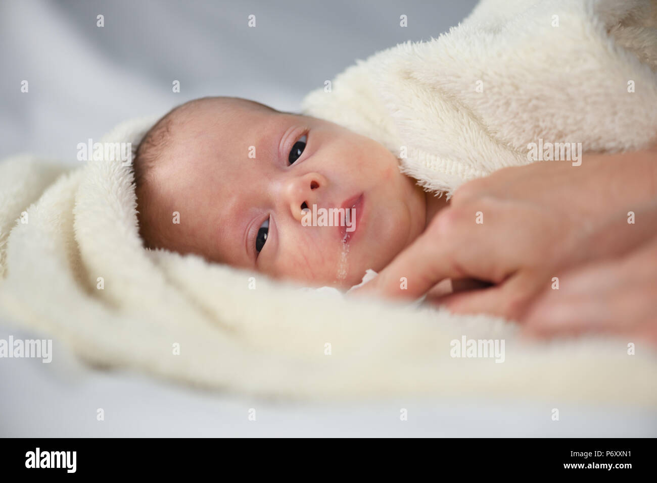 Newborn baby boy on white carpet closeup Stock Photo