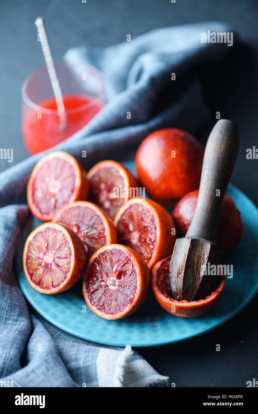 Red sicilian orange pieces on blue plate closeup Stock Photo