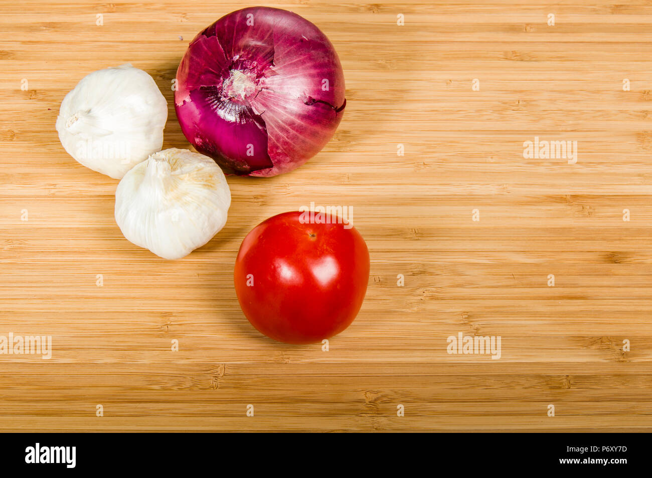 Tomato with cloves of garlic and a red onion Stock Photo - Alamy