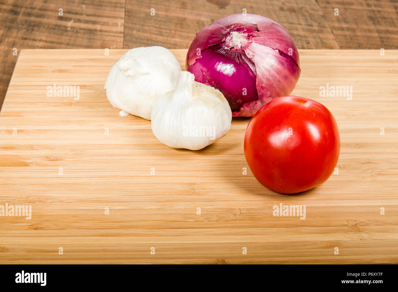 Tomato with cloves of garlic and a red onion Stock Photo - Alamy