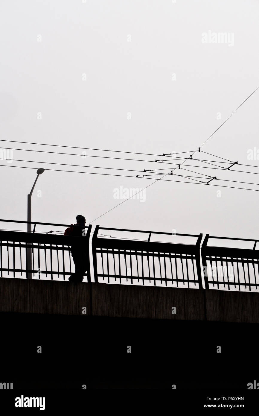 silhouette of a man walking on a bridge Stock Photo - Alamy