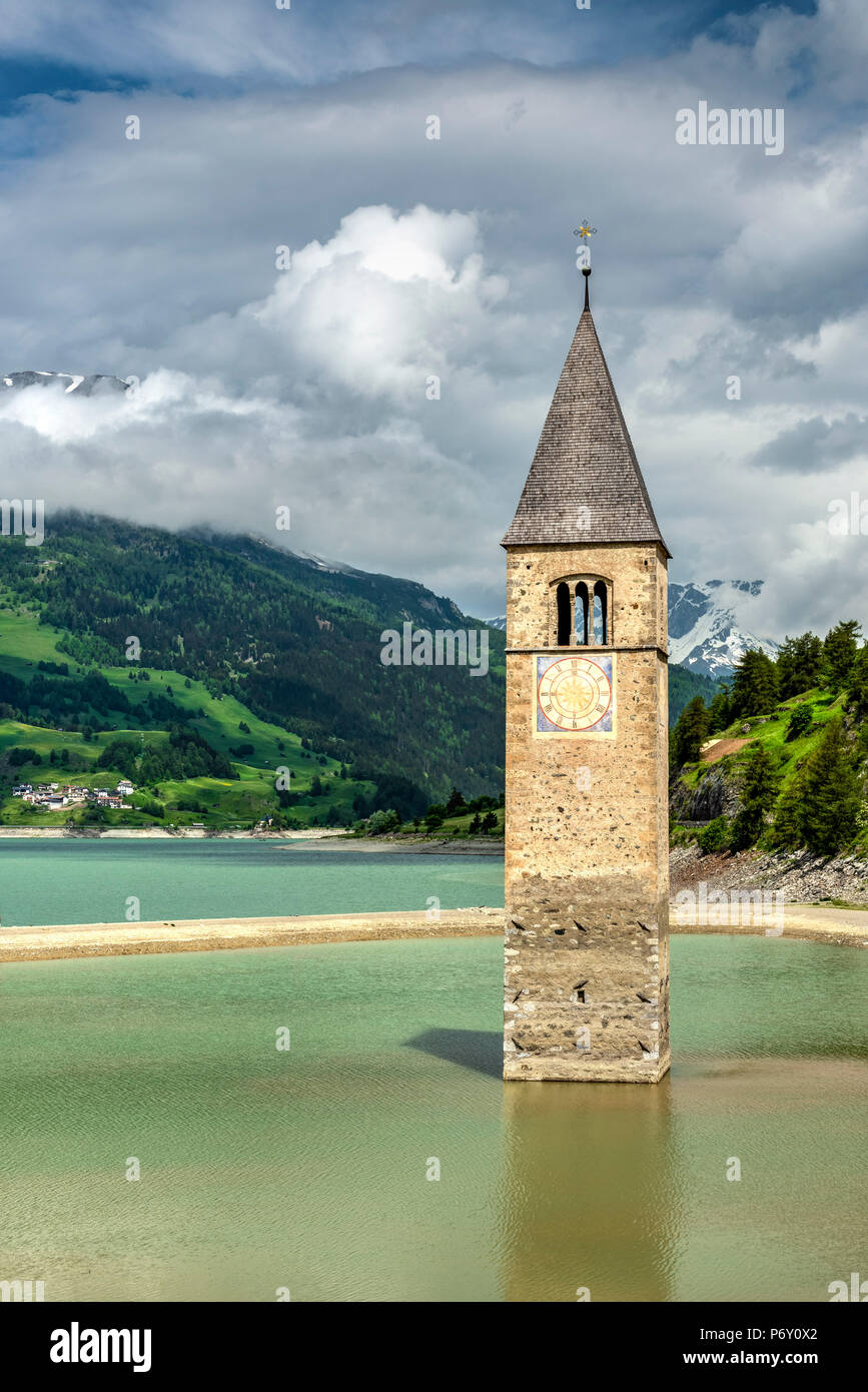 In 1950 the old village of Curon Venosta - Graun im Vinschgau, Trentino Alto Adige - South Tyrol, Italy, was abandoned and rebuilt later on the new shores as the local valley was dammed in order to produce hydro-electricity. The half-submerged bell tower of the old village has become a landmark since then and today has become a popular tourist attraction. Stock Photo
