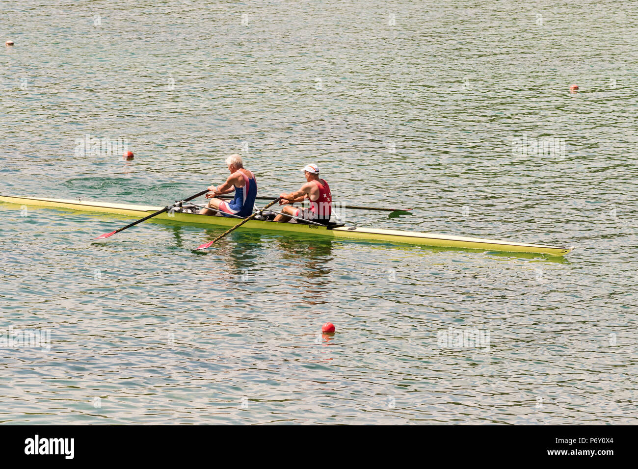 Rowers in rowing boats on the tranquil lake Stock Photo Alamy