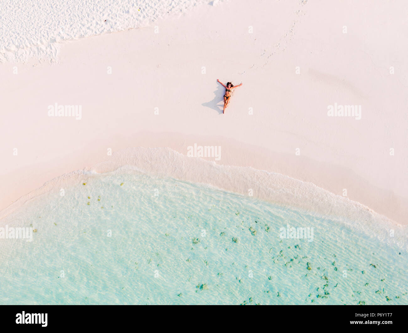 Aerial drone view of woman on a sandy beach, Maldives (MR) Stock Photo