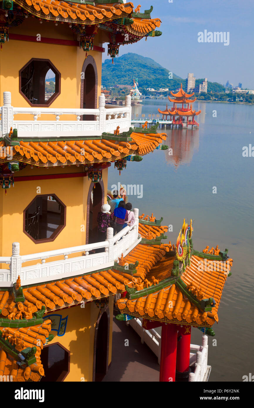 Taiwan, Kaohsiung, Lotus pond, Dragon and Tiger Tower Temple with view of bridge leading to Spring and Autumn pagodas and statue of Syuan Tian Emperor in background Stock Photo