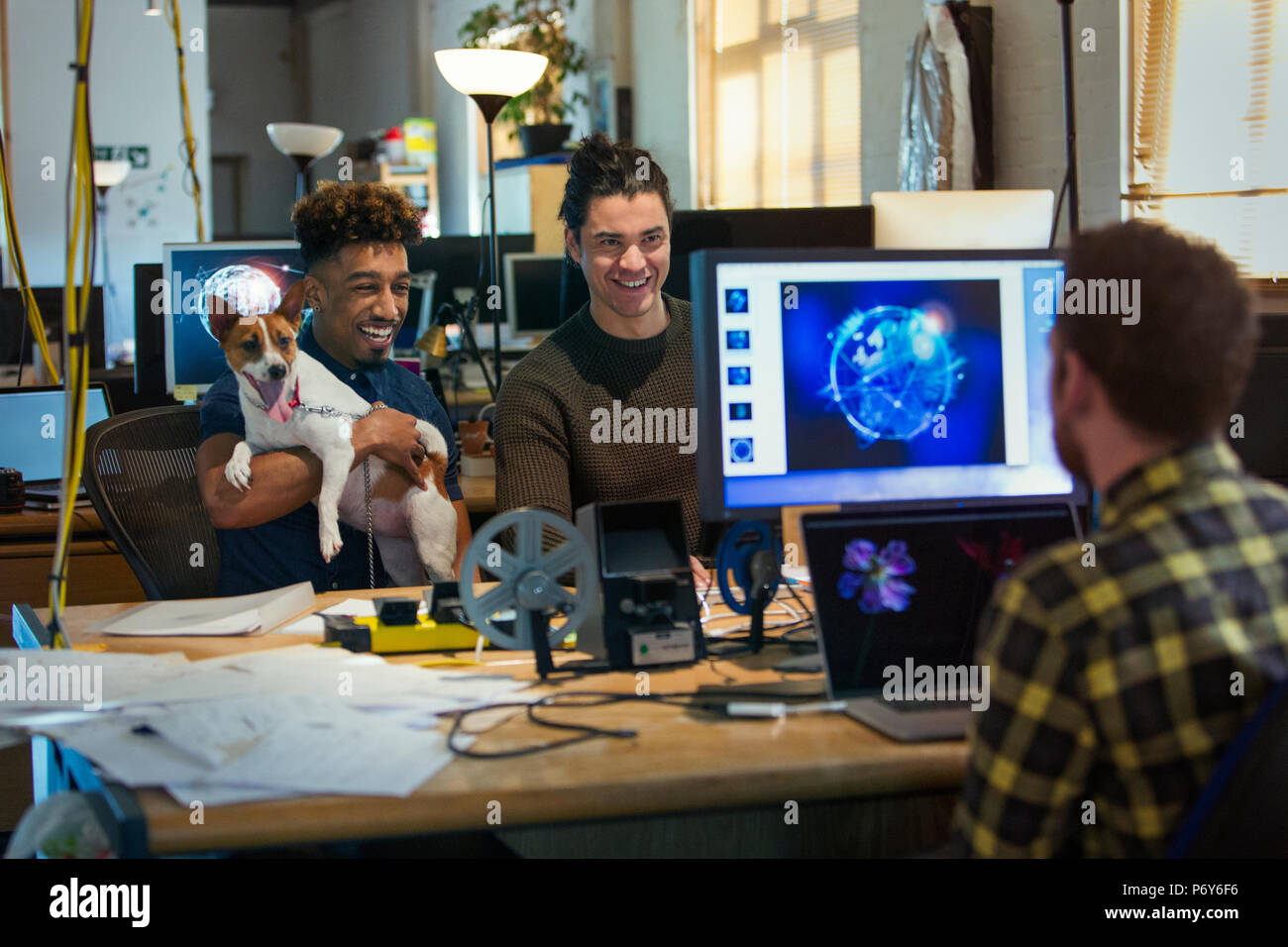 Creative business people with dog in open plan office Stock Photo