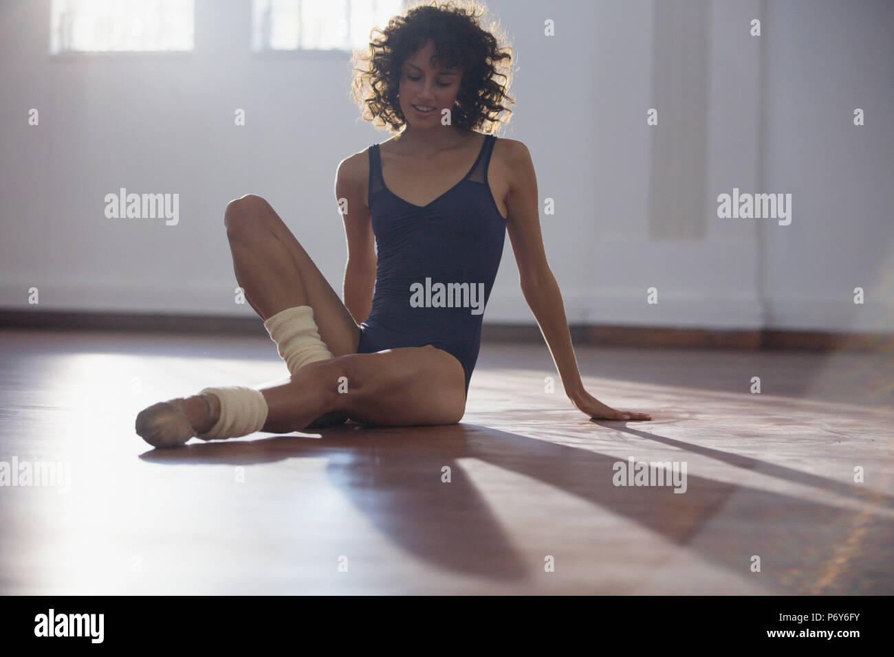 Young female dancer stretching in dance studio Stock Photo