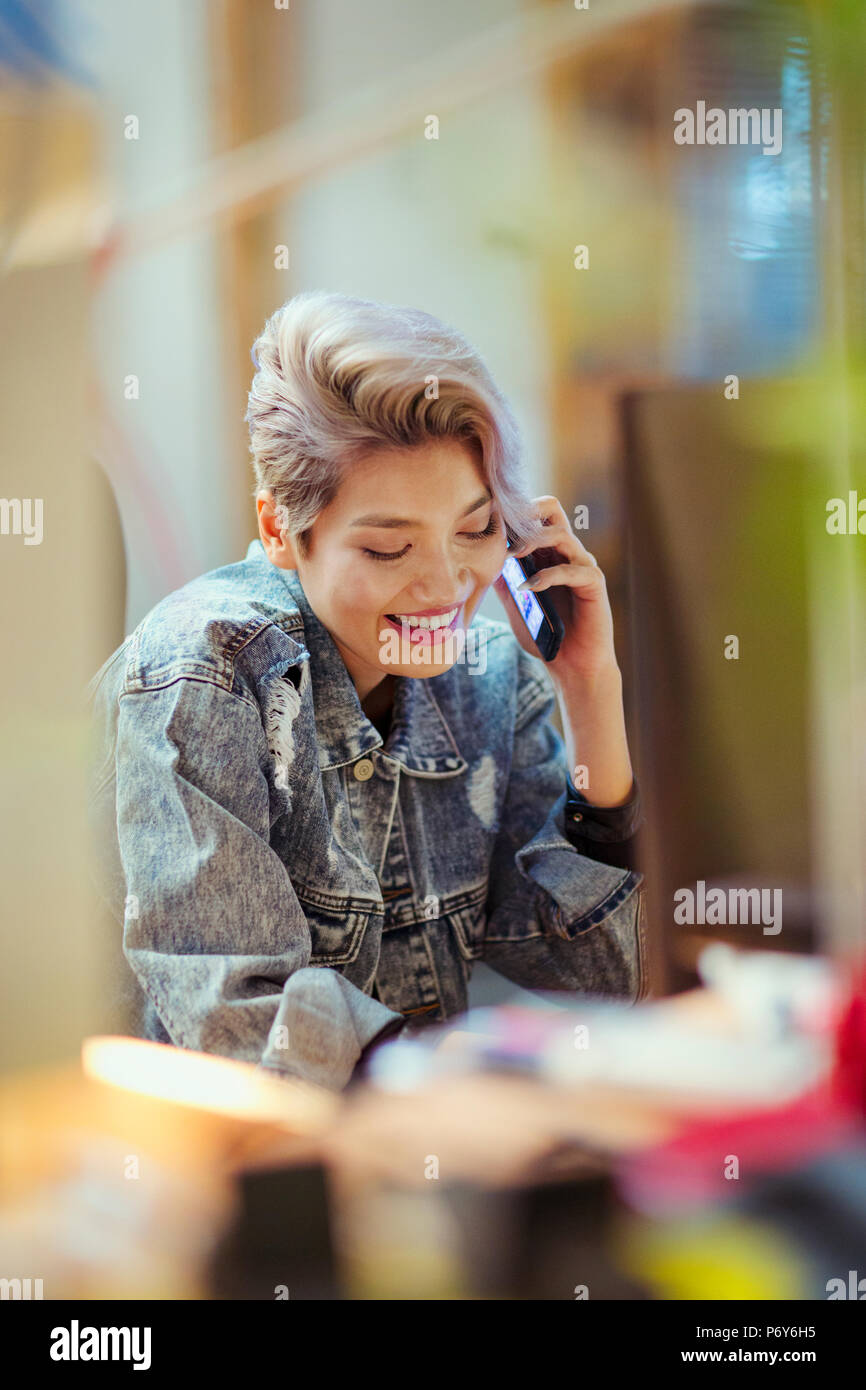 Smiling young woman talking on smart phone Stock Photo