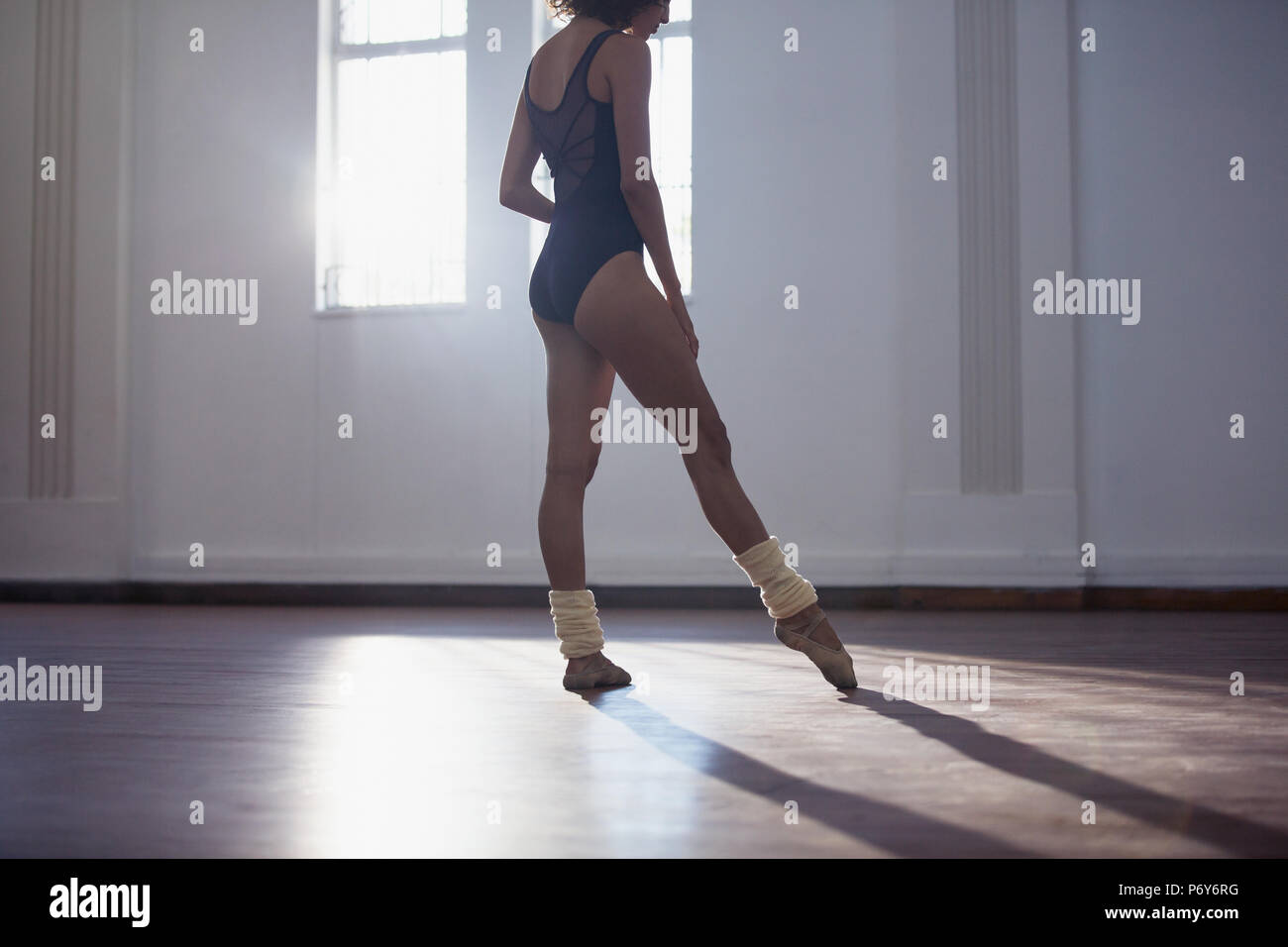 Graceful young female ballet dancer practicing in dance studio Stock Photo