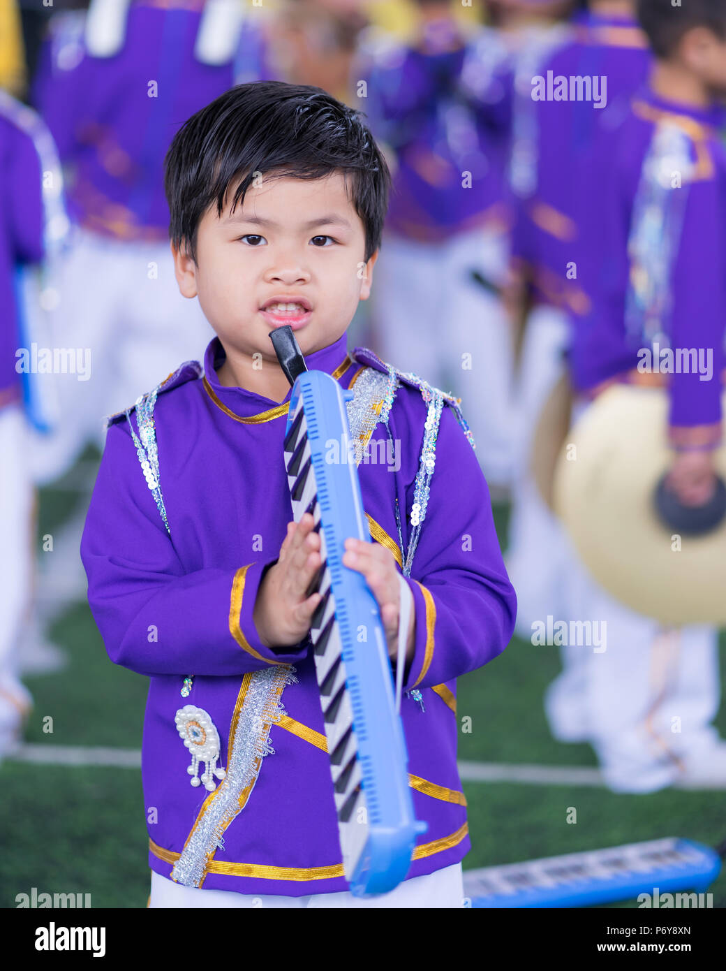 portrait cute Asian boy, little boy wear military band on holding melodion, Stock Photo