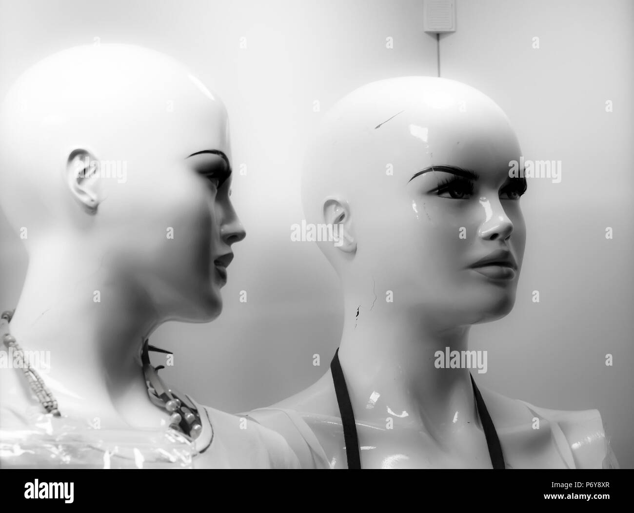 Close up of two female mannequin heads displayed n the shop window in black and white Stock Photo