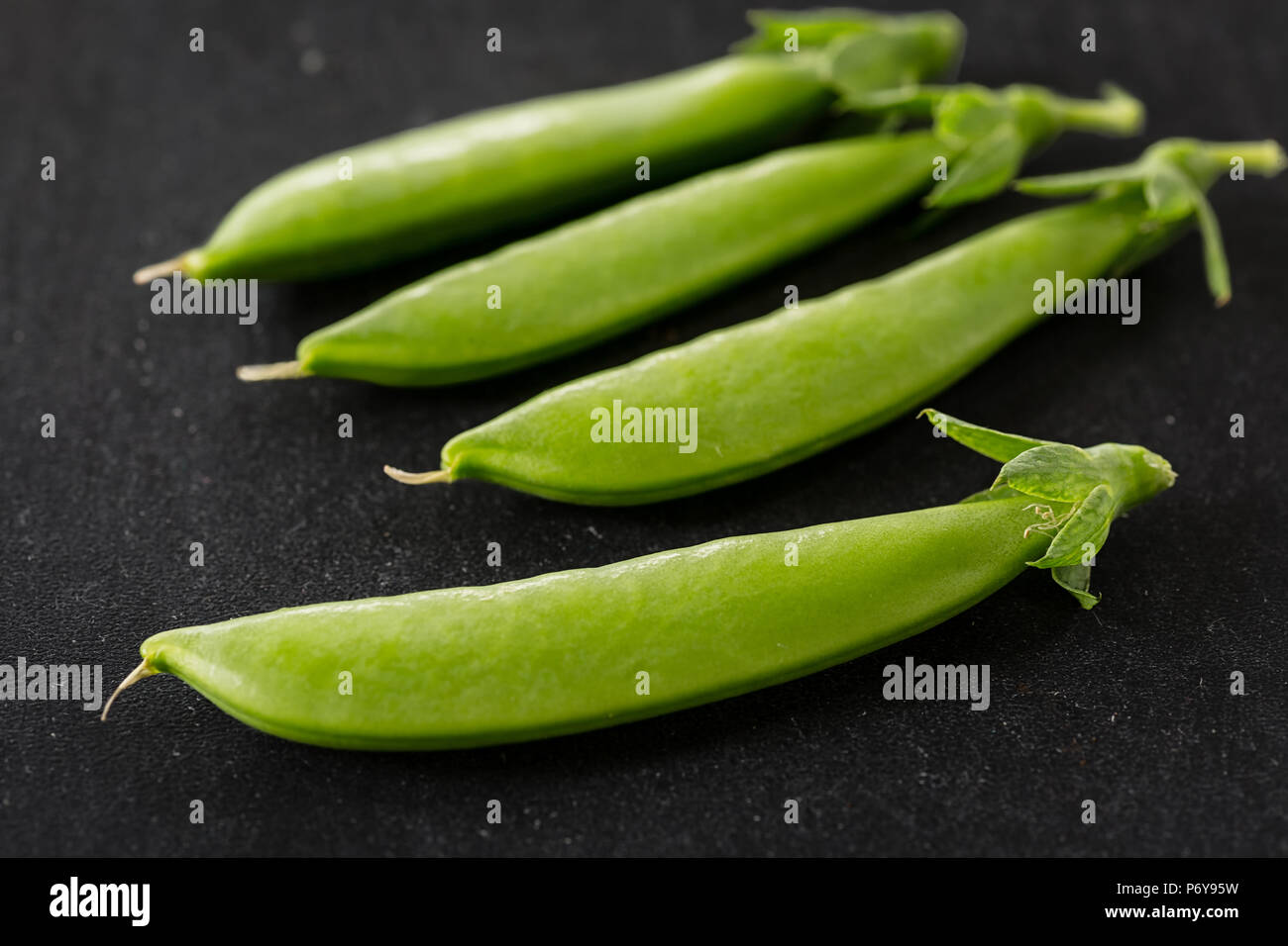 Freshly picked snow peas on a black background. Stock Photo