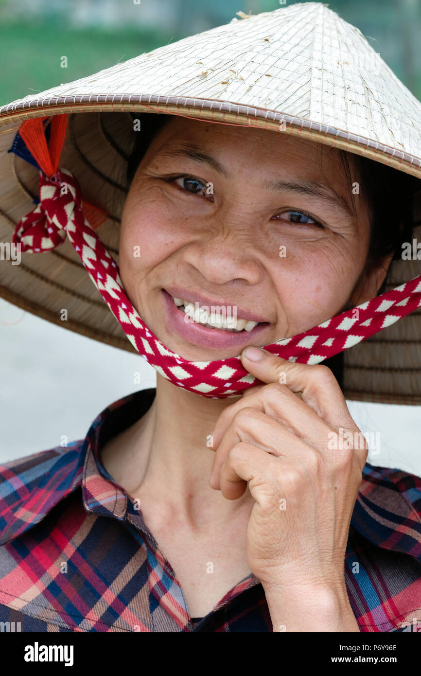 Smiling woman with rice paddy straw hat. Nam Dinh provice, Vietnam Stock Photo