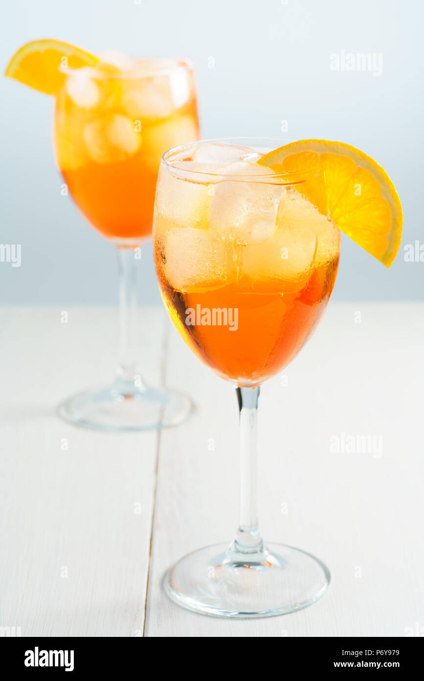 Aperol Spritz served with an orange slice in wine glasses. White ...