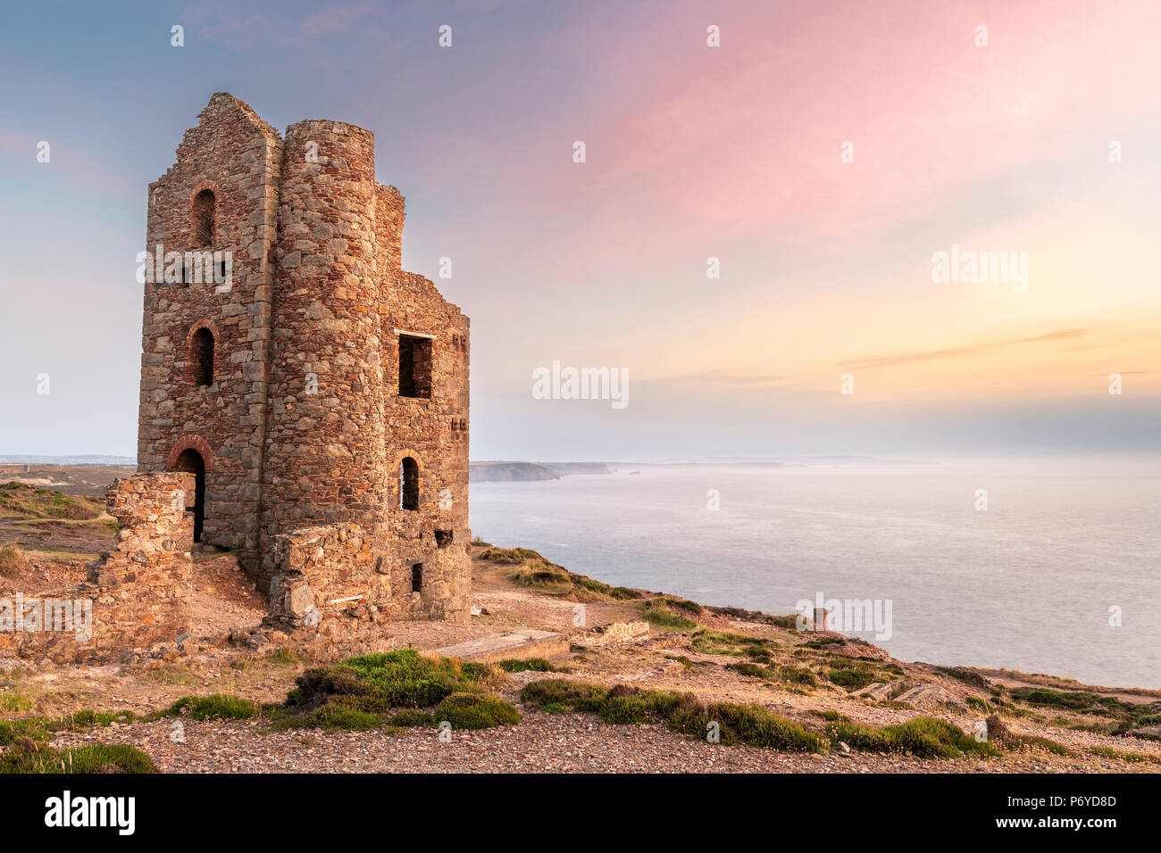 UK Weather - After another warm and humid  day the high cloud breaks to give a spectacular  sunset over the heather and gorse at Wheal Coates, deep in Stock Photo