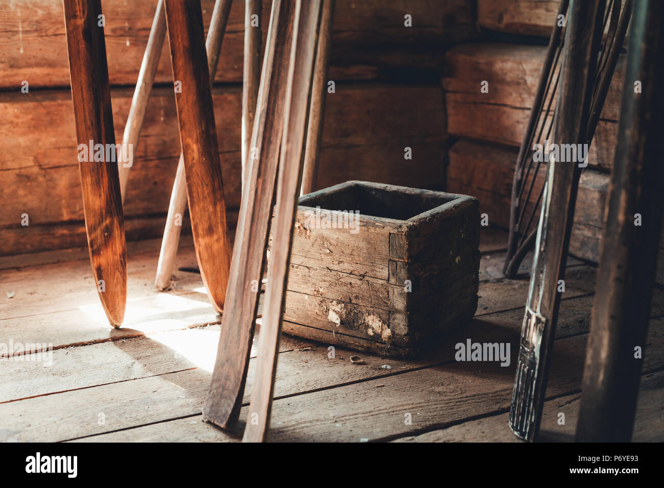 Rustic potato box and wooden skis in front of weathered girder walls Stock Photo