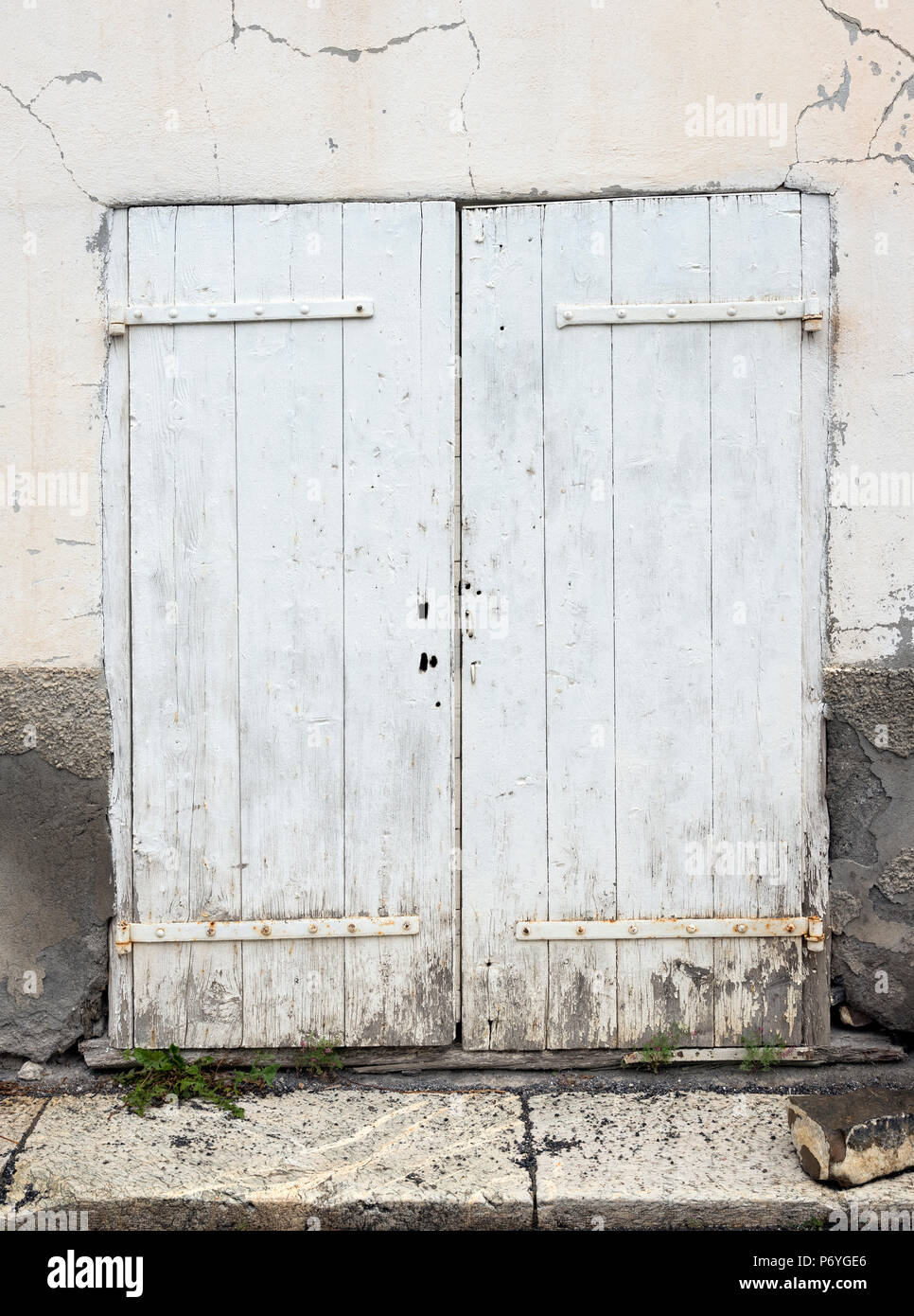 very old weathered white wooden doors of house in french provence Stock Photo