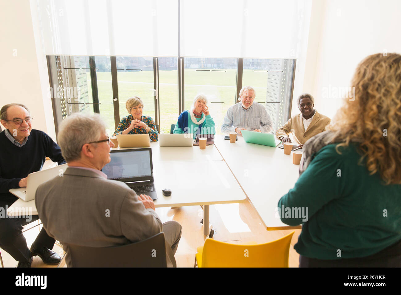 Senior business people using digital tablets and laptops in conference