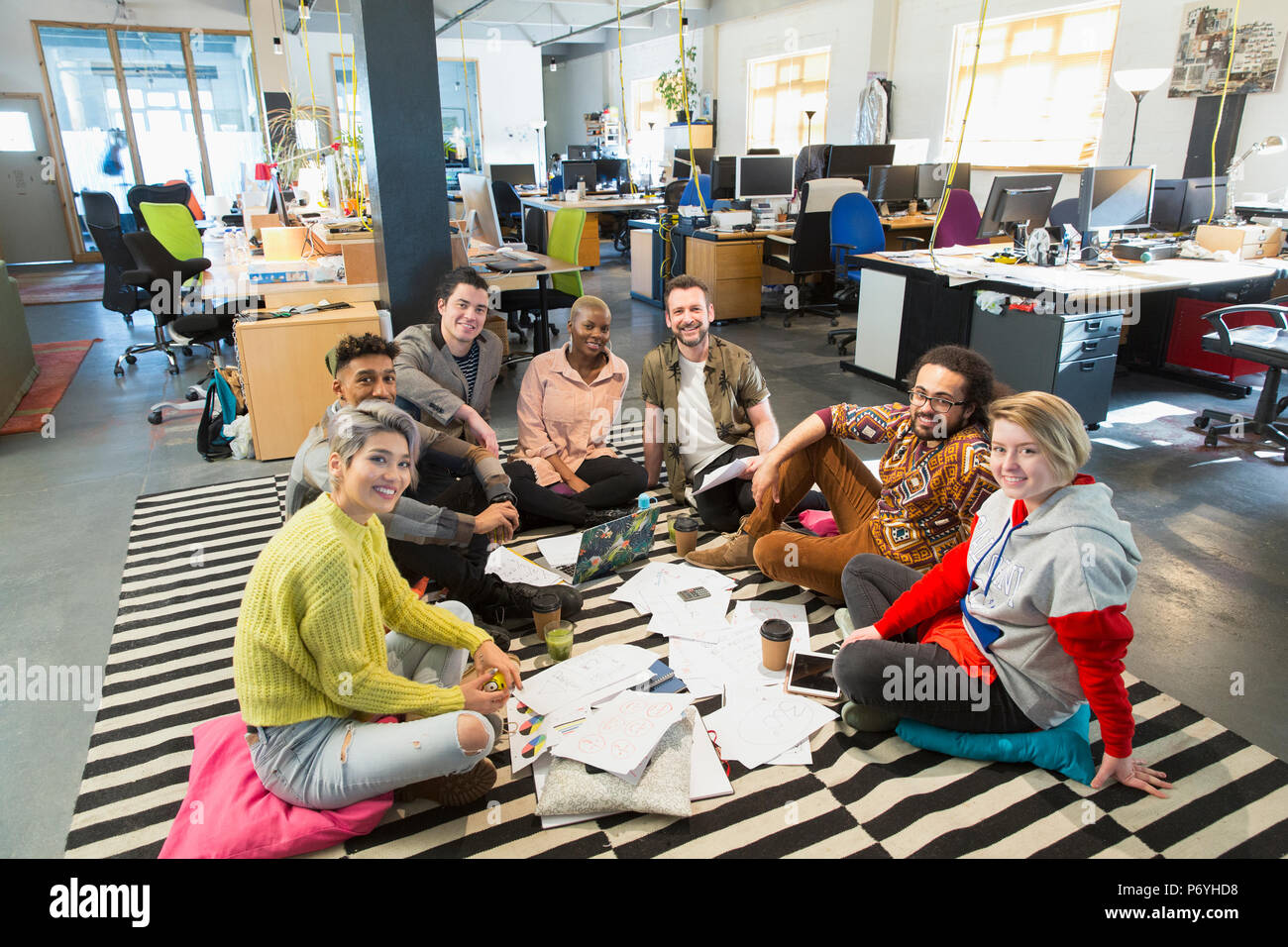 Portrait confident creative business team meeting, brainstorming in circle on office floor Stock Photo