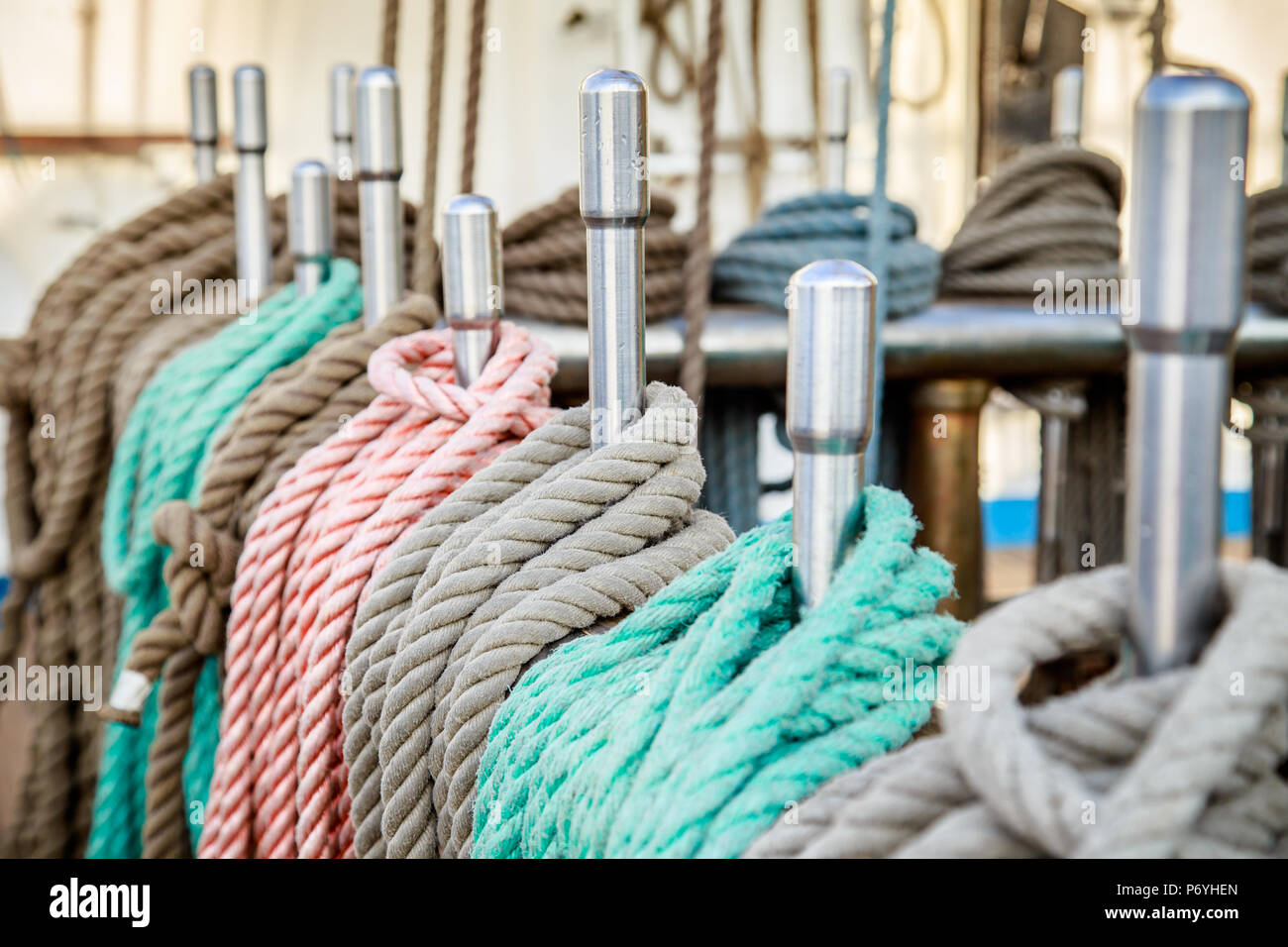 Colorful ropes looped around steel poles on ship's deck Stock Photo